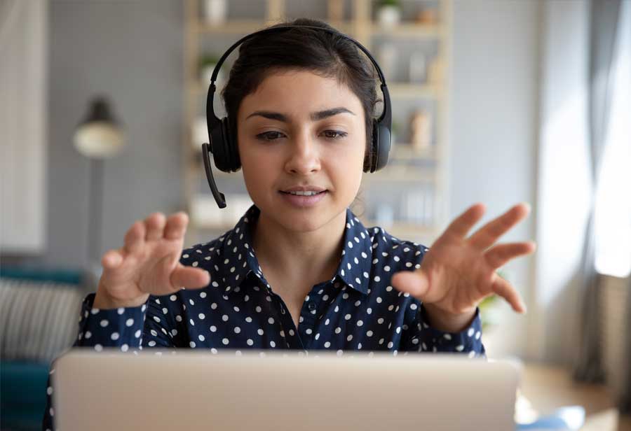 Young woman speaking to camera on laptop